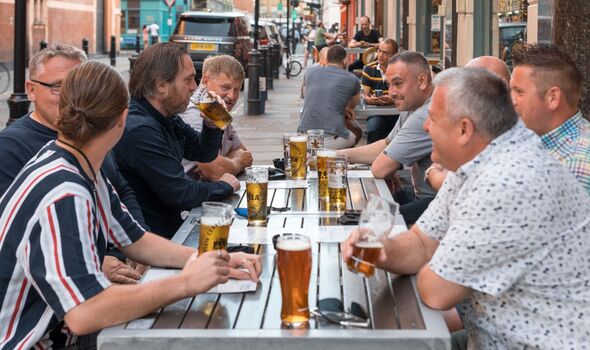 People seen drinking beer at a bar in Soho, London
