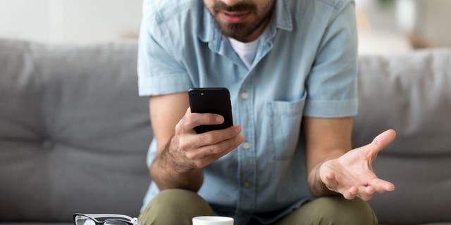 Man composes email on smartphone. 