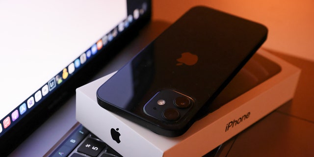 In this photo illustration, Apple's iPhone 12 seen placed on a MacBook Pro.