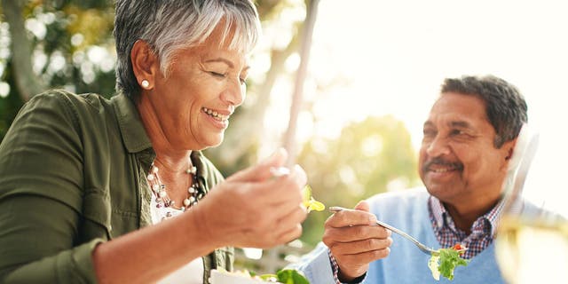 Shot of a happy older couple enjoying a healthy lunch together outdoors