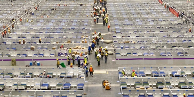 In this photo released by Xinhua News Agency, workers labor at the site of a temporary hospital being constructed at the National Exhibition and Convention Center (Shanghai) in east China's Shanghai, April 8, 2022. China's largest city of Shanghai will soon begin lifting lockdown in communities that report no positive cases within 14 days after another round of COVID-19 testing, authorities said Saturday.  