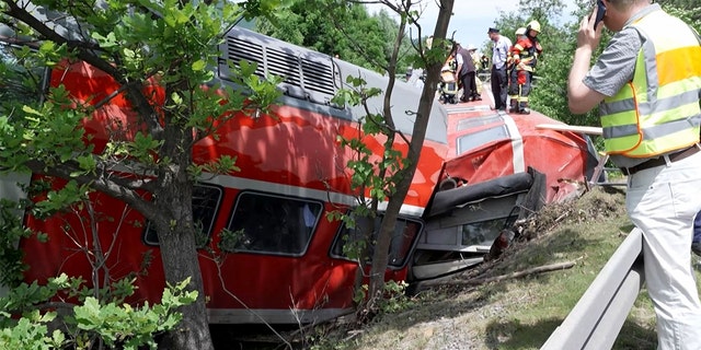 This video grab shows firemen and rescue helpers working around a derailed train on June 3, 2022, in Burgrain near Garmisch-Partenkirchen, southern Germany.