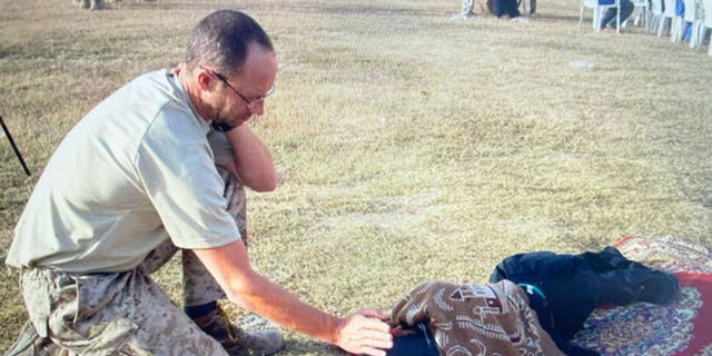 Mal James with a child while on assignment.