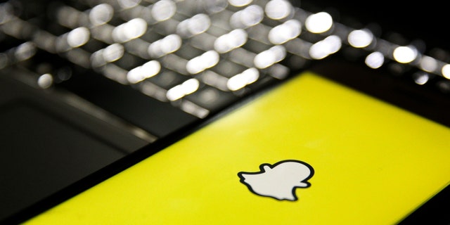 In this photo illustration, a mobile phone screen displays the Snapchat logo in front of a keyboard in Istanbul, Turkey, Feb. 24, 2020. 