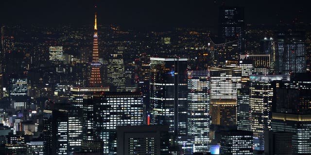 The illuminated Tokyo Tower is among the commercial and residential buildings dominating Tokyo's evening skyline on Dec. 8, 2022.